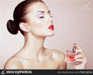 Young beautiful woman with bottle of perfume. Perfect Makeup. Fashion photo