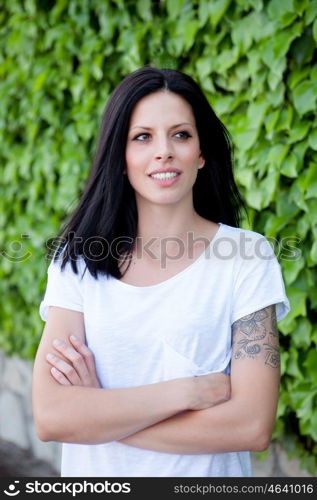 Young beautiful woman with brunette hair and perfect smile posing in park