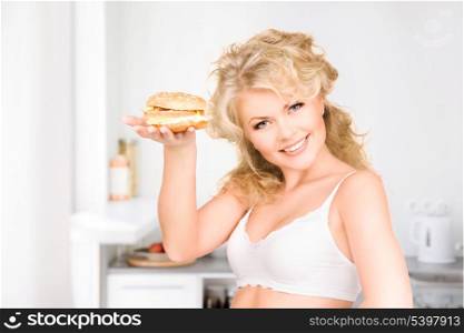 young beautiful woman with burger at home