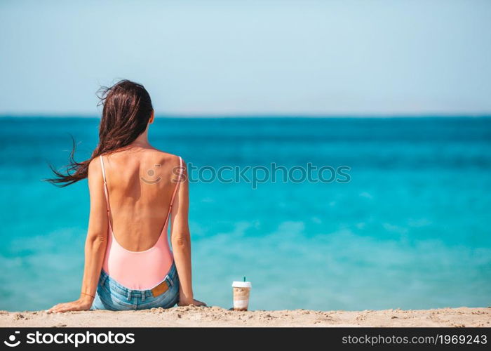 Young beautiful woman with coffee on the beach during tropical vacation. Young beautiful woman with coffee on the beach during tropical summer vacation