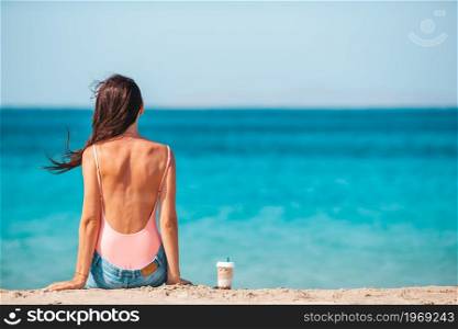 Young beautiful woman with coffee on the beach during tropical vacation. Young beautiful woman with coffee on the beach during tropical summer vacation