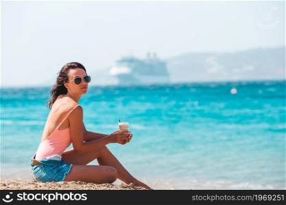 Young beautiful woman with coffee on the beach during tropical vacation. Young beautiful woman with coffee on the beach during tropical summer vacation