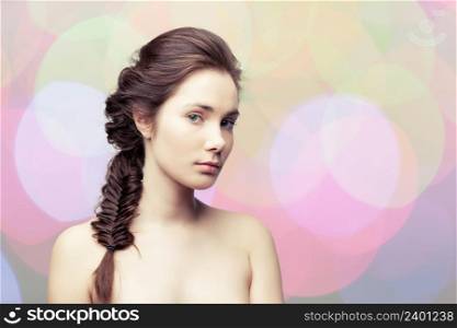 Young beautiful woman with elegant hairdo on colorful pastel background