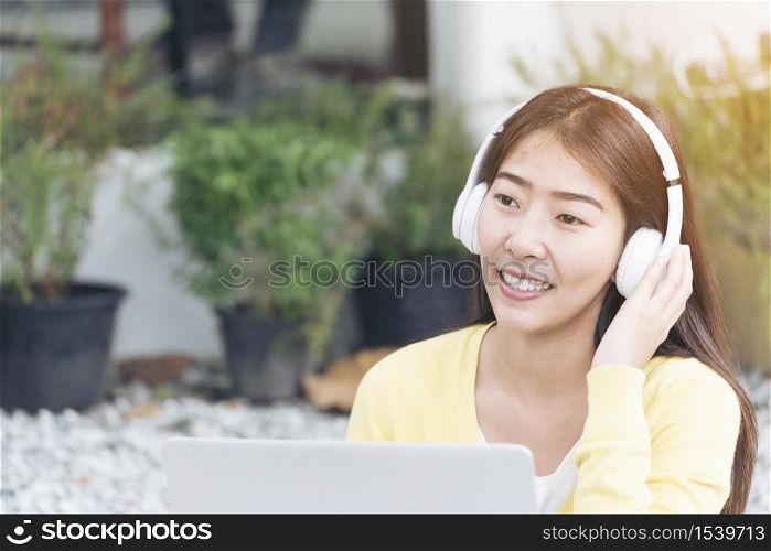 Young beautiful woman with happy face while listen to music from headphone and working on laptop. woman with technology lifestyle. Music happy life with funny girl.
