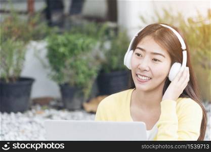 Young beautiful woman with happy face while listen to music from headphone and working on laptop. woman with technology lifestyle. Music happy life with funny girl.