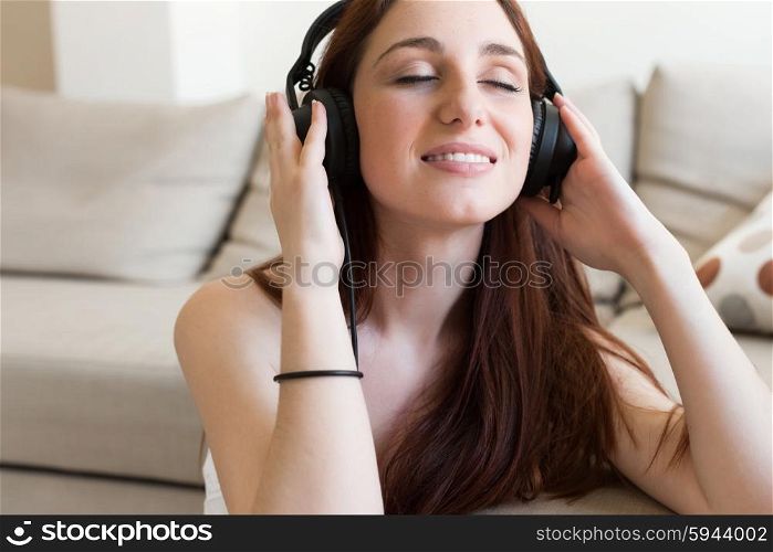 young beautiful woman with headphones at home