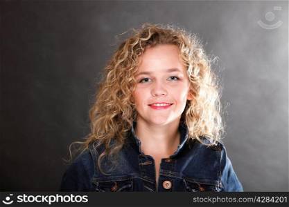 Young beautiful woman with long curly blond hair on grey background