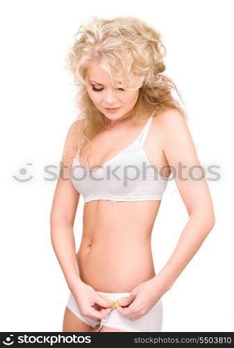 young beautiful woman with measure tape over white