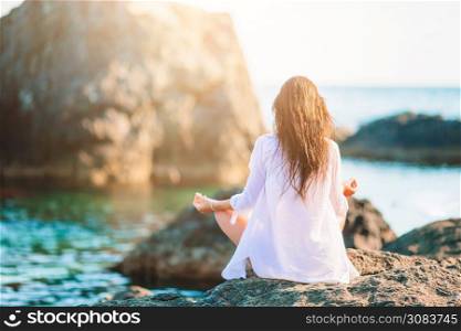Young beautiful woman woman practicing yoga at seashore. Young beautiful woman on yoga on the beach