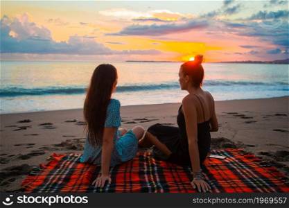 Young beautiful women on the beach vacation. Women on the beach enjoying summer holidays looking at the sea
