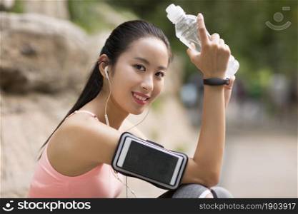 Young beauty drinking water and taking a rest after working out