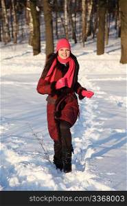 young beauty girl in pink scarf and hat smiling and walking to front outdoor at winter day