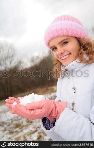 young beauty girl outdoor in winter holds snow in hands