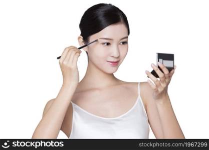 Young beauty making up her eyebrows