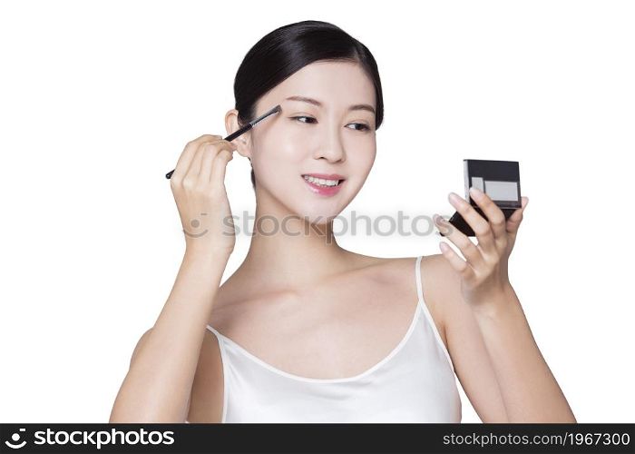 Young beauty making up her eyebrows
