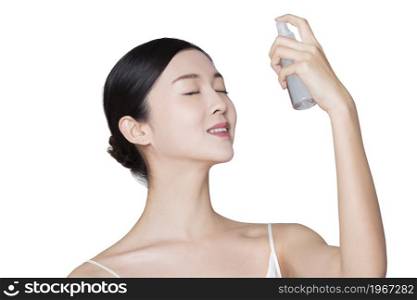 Young beauty spraying skin care products