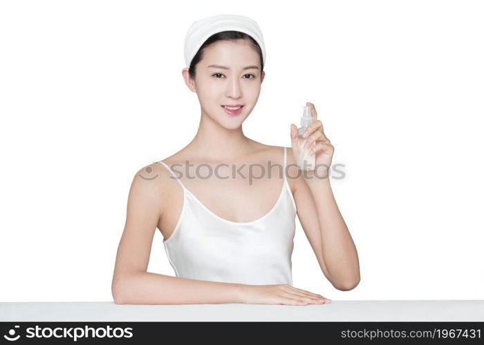 Young beauty spraying skin care products