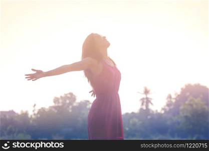 Young beauty woman happy relaxing smile with sunglasses and pink dress cloth in summer sunset sky outdoor. People freedom style.