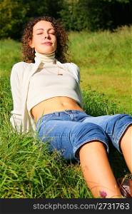 young beauty woman outdoor sits on grass