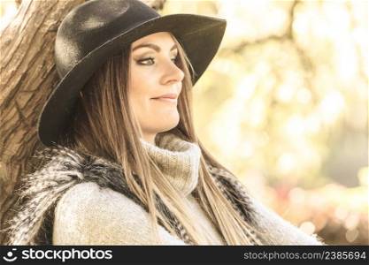 Young beauty woman wearing stylish autumnal clothes relaxing in park. Portrait of fashionable caucasian girl student resting on air.. Beautiful autumnal woman in park