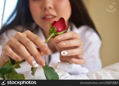 Young beauty women with rose flower is on bedroom