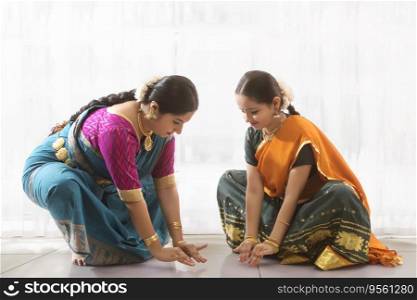 Young bharatnatyam dancer learning from her teacher. 