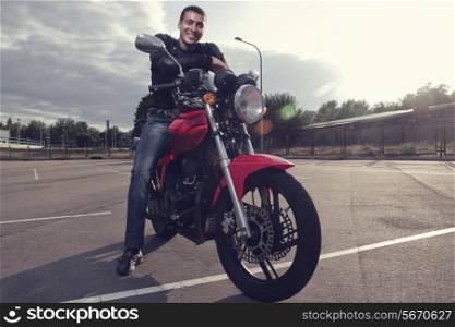 Young biker sitting on sporty motorcycle
