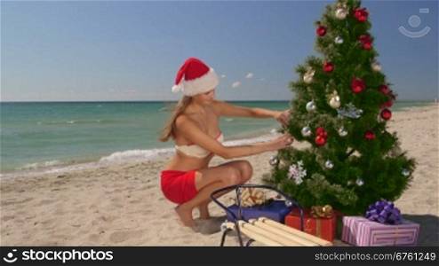 Young bikini woman spends Christmas vacations on the tropical beach