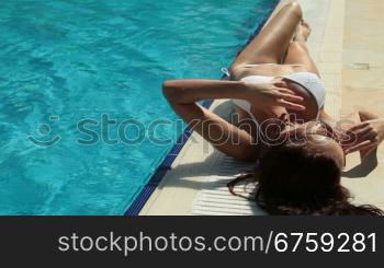 Young Bikini Woman Sunbathing by Swimming Pool