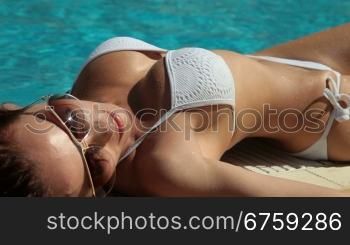 Young Bikini Woman Sunbathing by Swimming Pool