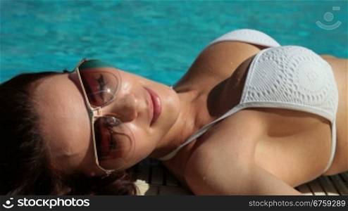 Young Bikini Woman Sunbathing by Swimming Pool