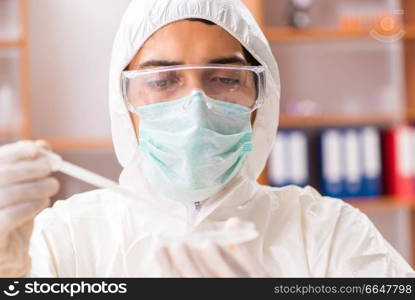 Young biochemist wearing protective suit working in the lab