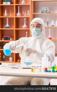 Young biochemist wearing protective suit working in the lab