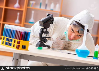 Young biochemist wearing protective suit working in the lab