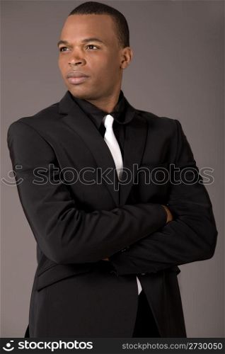 Young black american business man with folded hands on a grey background