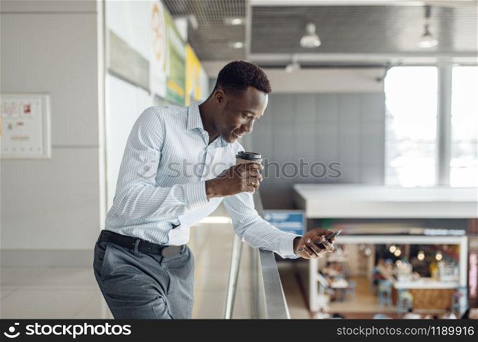 Young black businessman with cup of coffee, food-court. Successful business person in office cafe, black man in formal wear. Black businessman with cup of coffee, food-court