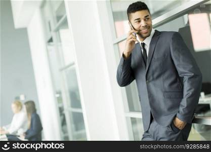 Young black businessman with mobile phone in the office