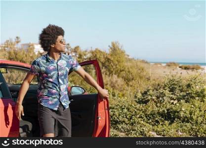 young black man coming out car nature