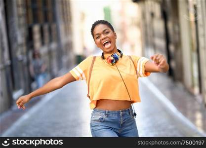 Young black woman is dancing on the street in Summer. Girl traveling alone. Lifestyle concept.. Young black woman is dancing on the street in Summer. Girl traveling alone.