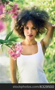 Young black woman with afro hairstyle in urban park. Mixed girl wearing casual clothes.