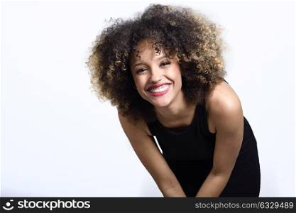 Young black woman with afro hairstyle laughing. Girl wearing black dress. Studio shot.