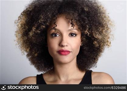 Young black woman with afro hairstyle on white background. Girl with african hairstyle. Studio shot.