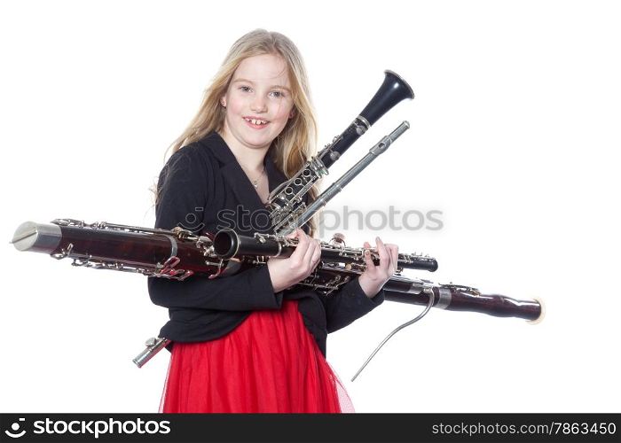 young blond girl holds woodwind instruments in studio against white background
