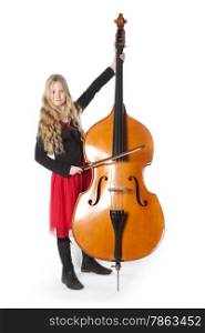 young blond girl in red dress plays double bass in studio against white background