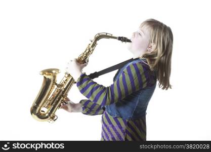 young blond girl plays alto saxophone against white background in studio