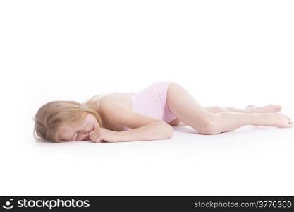 young blond girl sleeping on the floor of studio against white background