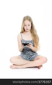 young blond girl with mobile phone in studio against white background