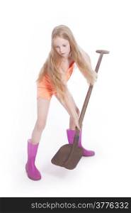 young blond girl working with shovel in studio against white background