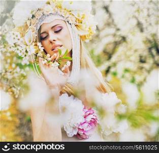 Young blond lady in the fragrant spring garden