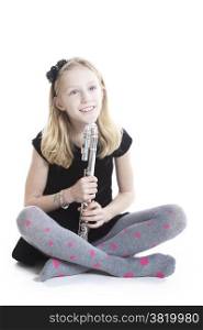 young blond smiling girl holding flute in studio against white background
